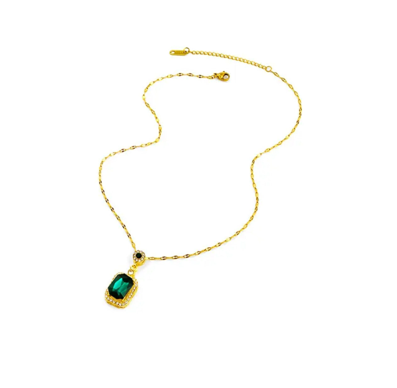 Gold chain necklace with rectangular green gemstone pendant bordered by clear crystals on a white background