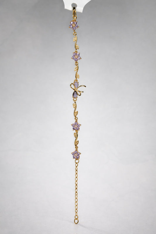 Gold bracelet with purple amethyst flowers and butterfly charm hanging vertically