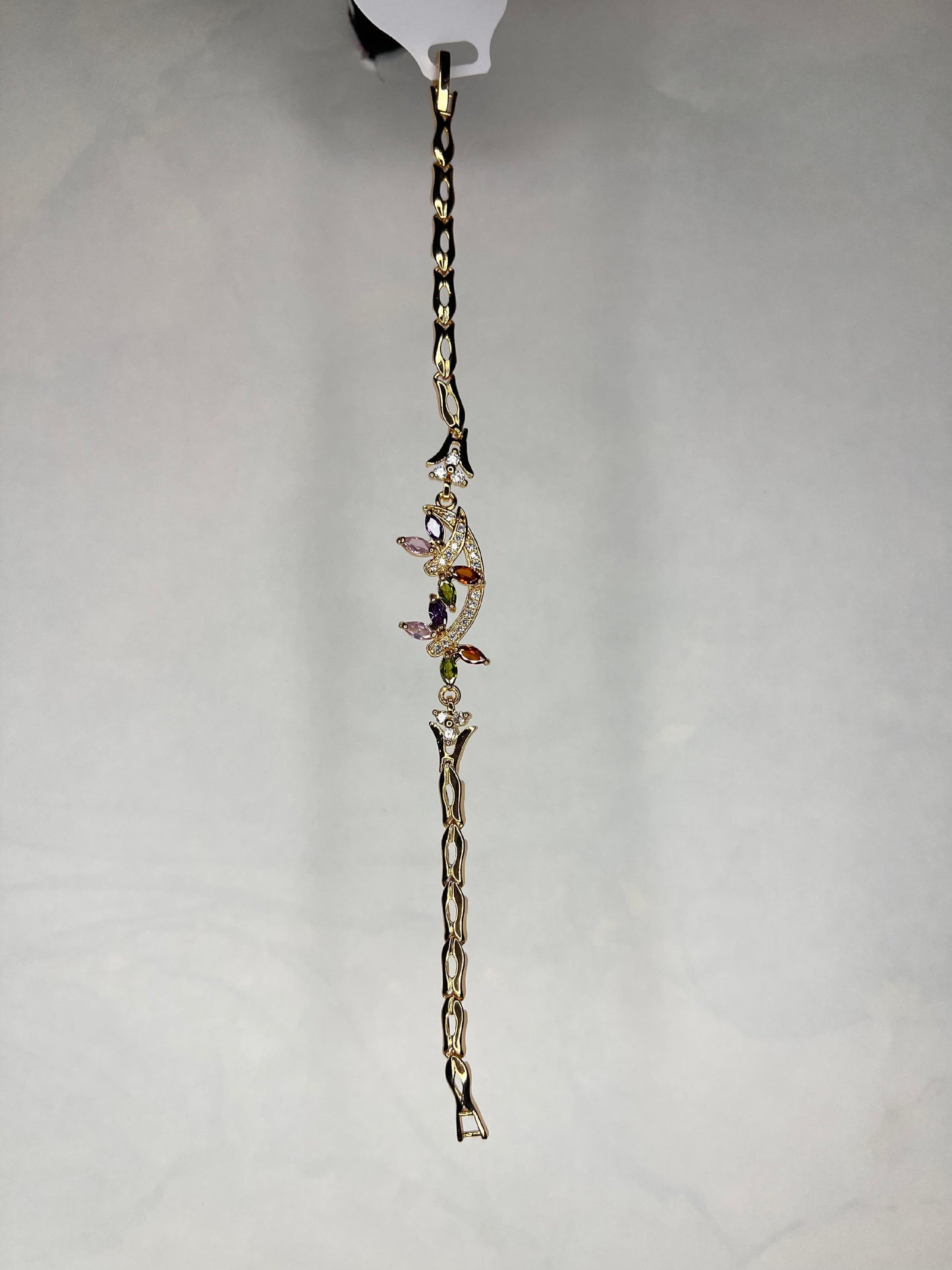 Gold plated multi-stone bracelet displayed against a light gray background